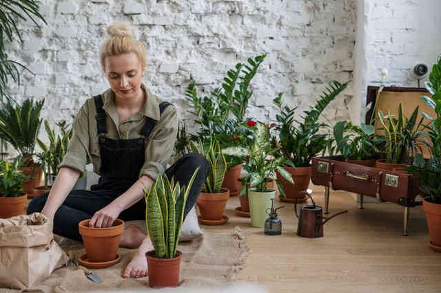 Woman meditating while tending to her garden plants